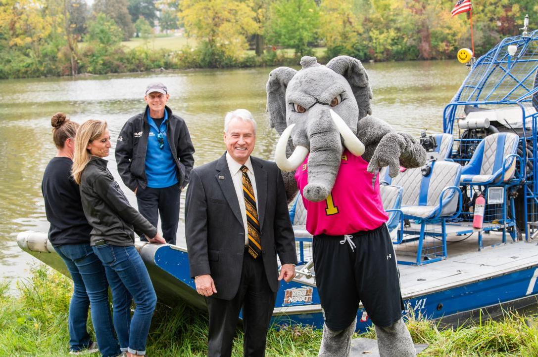 Chancellor standing with Don in from of a boat.